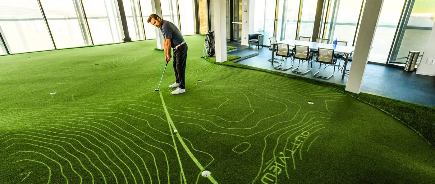 A golfer putting on a PuttView green with glowing contour lines and a tracked putt line